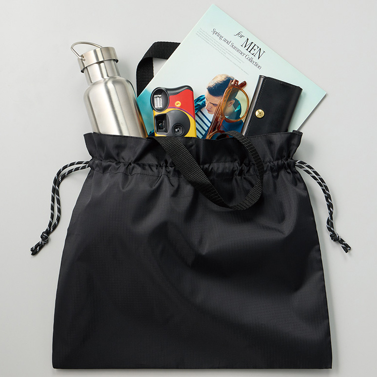 最初に手に取ったとき「巾着ってこんなに便利だったっけ?」と驚きました。開け閉めが本当にラクなんです。ギャザー仕様だからスッと開いて、クシュっと閉じるだけ。しかも見た目まで柔らかい雰囲気で、普段使いのバッグにしても自然に馴染みます。
実際にA4サイズの雑誌やマイボトルを入れて出かけたときも、余裕のあるサイズ感で想像以上に使いやすかったです。ちょっとした買い物やお散歩、おしゃれなエコバッグ感覚でも使えるので、気がついたら毎日持ち歩くようになっていました。
しかも黒ベースのデザインにシンプルな巾着スタイルだから、男女問わず使いやすいのもポイント。正直ひとつ持っていると、ふだんの生活からアウトドアまで幅広く活躍してくれる、頼もしいバッグだと思います。